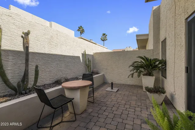 a view of a balcony with chairs and a potted plant