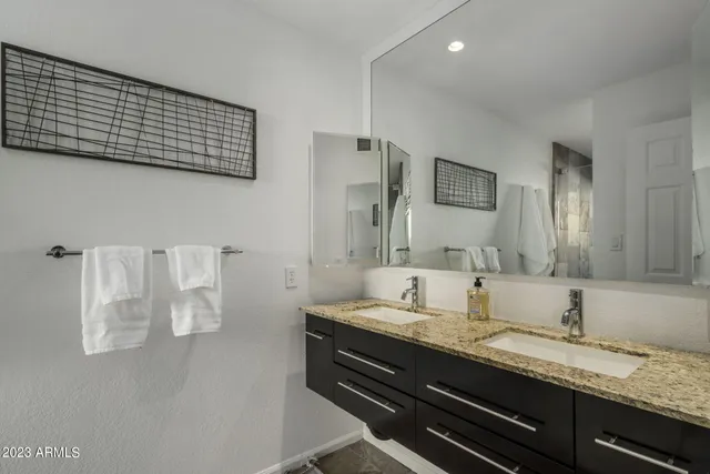 a bathroom with a granite countertop sink and a mirror