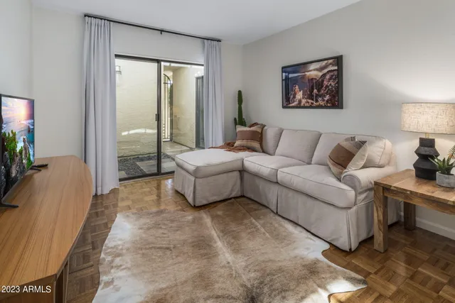 a living room with furniture a couch and painting on the wall