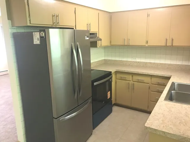 a metallic refrigerator freezer sitting in a kitchen