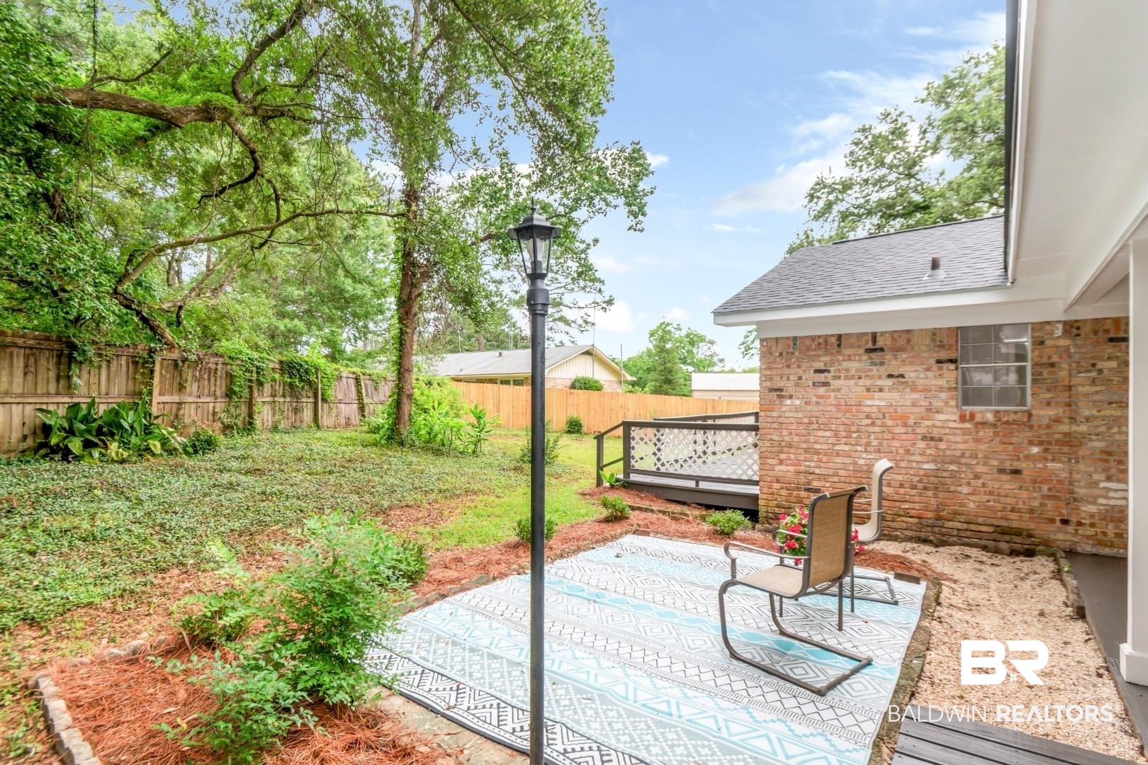 5217 Perin Road Mobile, AL 36693 - Photo 34 of 45 Private backyard area featuring a brick exterior, a wood-finish deck, an outdoor patio space, and mature trees
