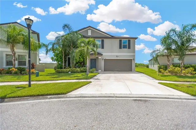 a front view of a house with a yard and garage