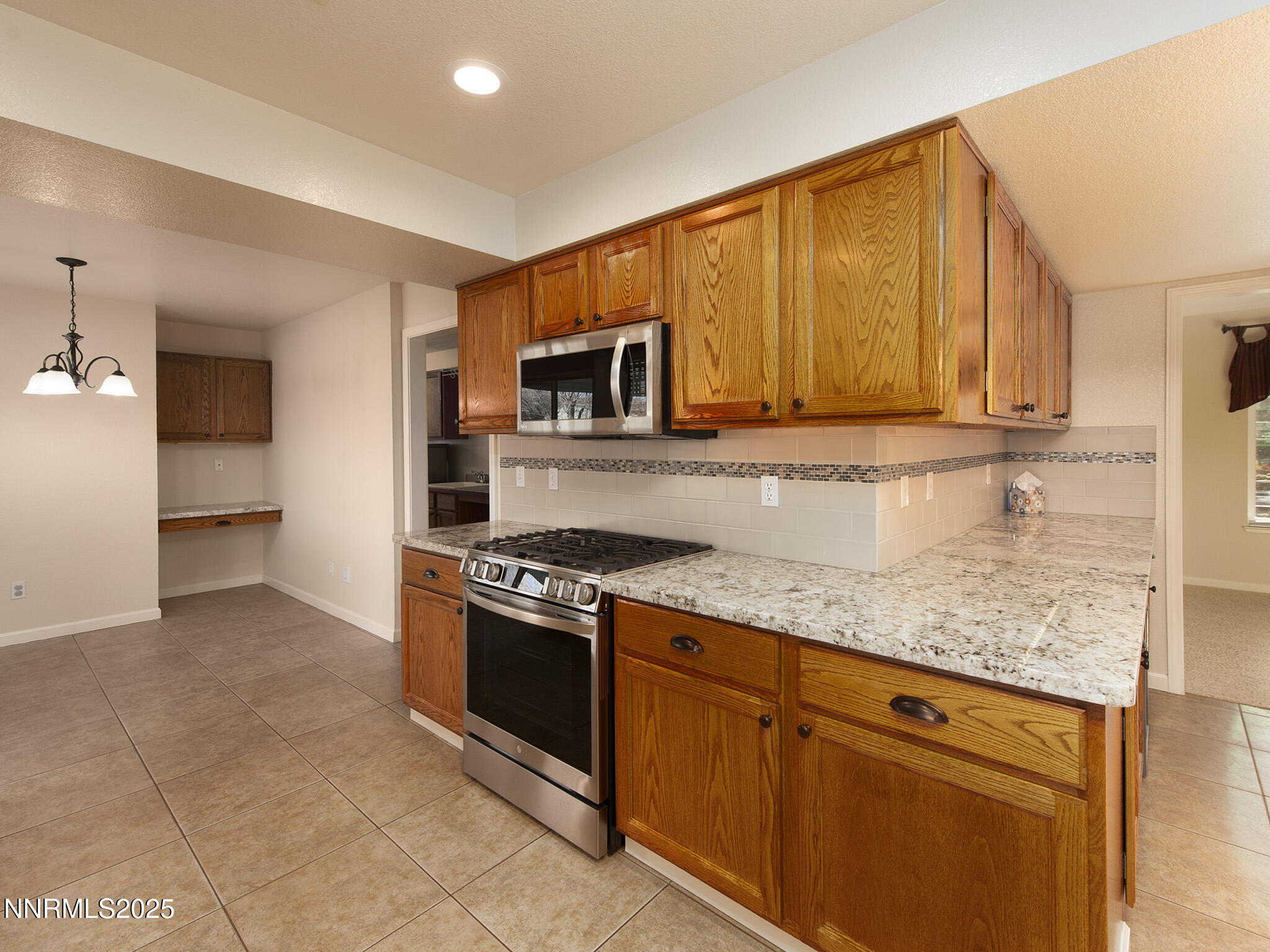 25 Nives Court Sparks, NV 89441 - Photo 18 of 67 a kitchen with stainless steel appliances granite countertop a stove a sink and a microwave