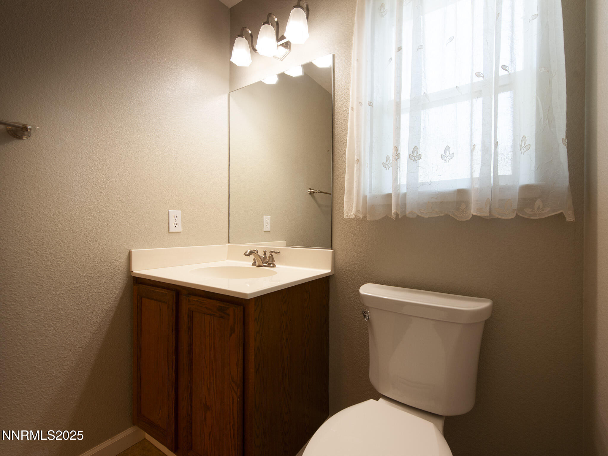 25 Nives Court Sparks, NV 89441 - Photo 34 of 67 a bathroom with a toilet a sink and mirror