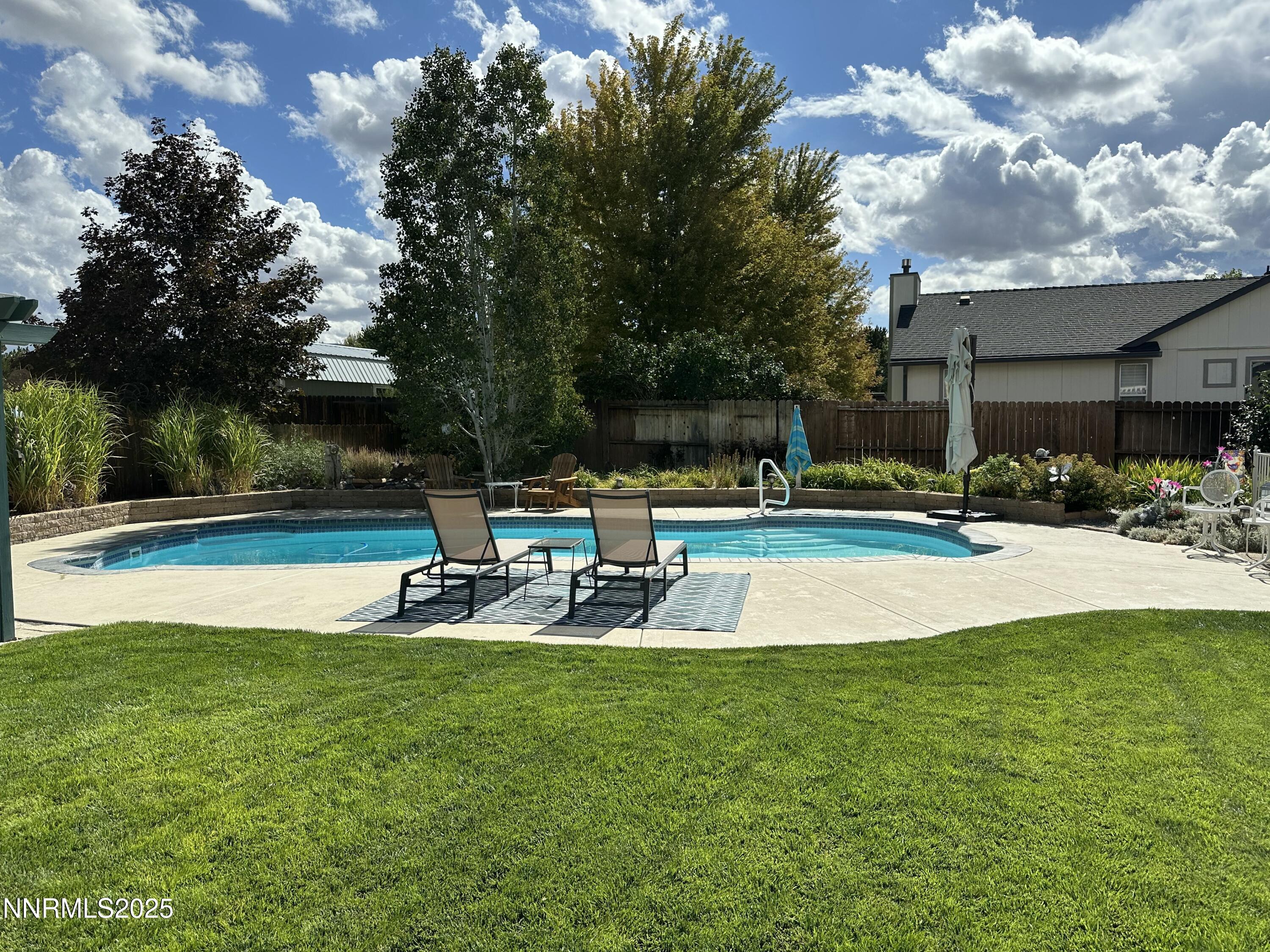 25 Nives Court Sparks, NV 89441 - Photo 35 of 67 a view of a swimming pool with lawn chairs and a fire pit