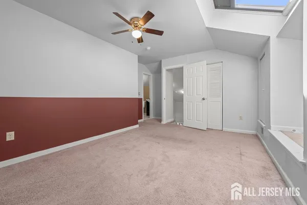 an empty room with a ceiling fan and window