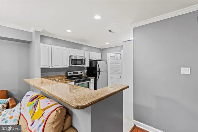 a kitchen with stainless steel appliances granite countertop a sink and a refrigerator