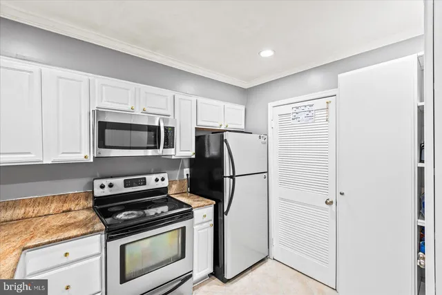 a kitchen with white cabinets and stainless steel appliances