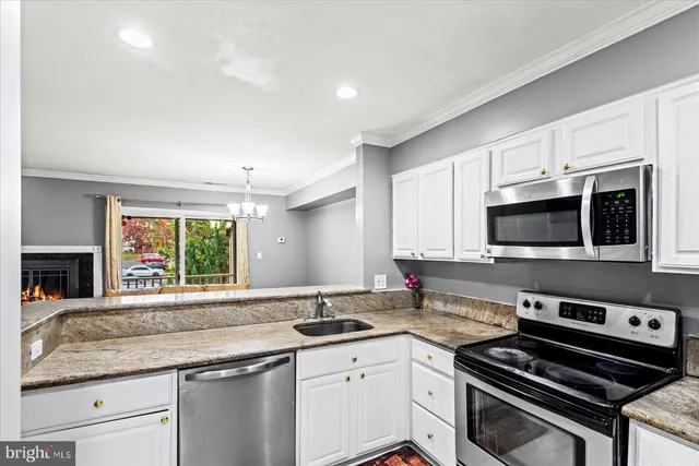 a kitchen with stainless steel appliances a sink stove and microwave
