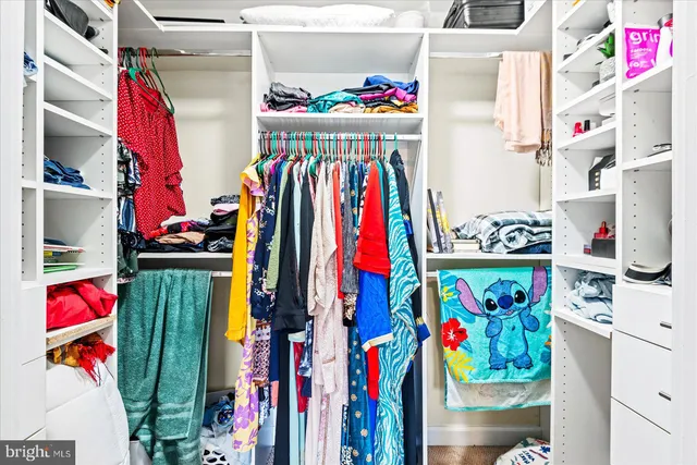 a view of walk in closet with clothes