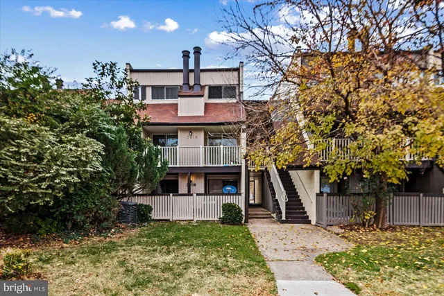 a front view of a house with a tree