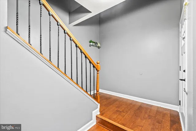 a view of staircase with wooden floor and white walls