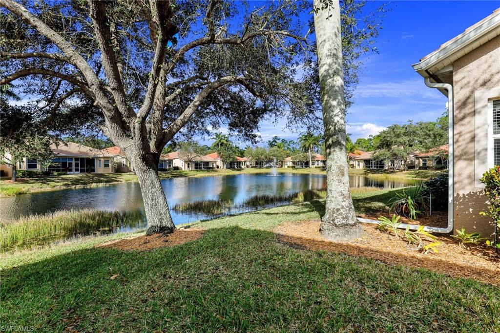 8133 Chancel Court, Unit 641 Naples, FL 34104 - Photo 13 of 13 a view of a lake with a bench and trees around