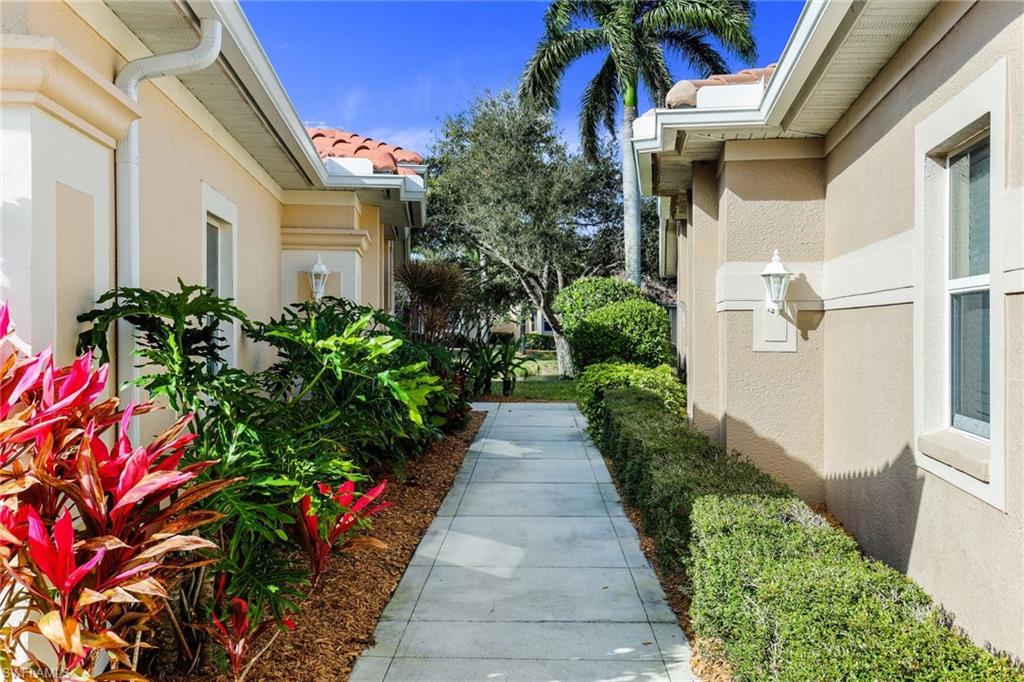 8133 Chancel Court, Unit 641 Naples, FL 34104 - Photo 2 of 13 a view of a pathway with house on both side