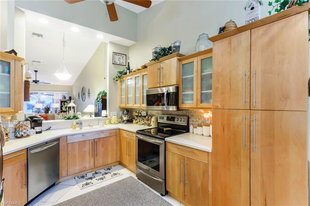 8133 Chancel Court, Unit 641 Naples, FL 34104 - Photo 5 of 13 a kitchen with a sink a stove cabinets and a refrigerator