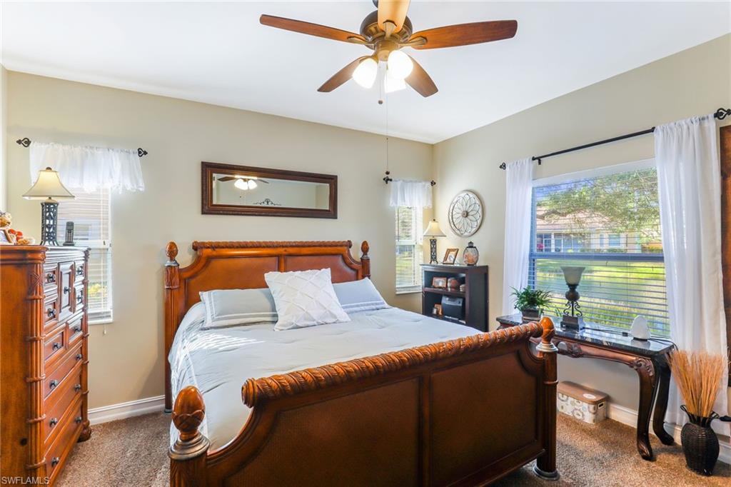 8133 Chancel Court, Unit 641 Naples, FL 34104 - Photo 8 of 13 a bedroom with a bed and a chandelier