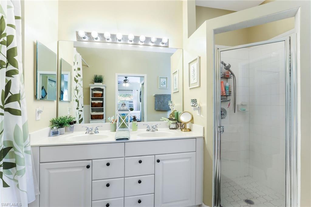 8133 Chancel Court, Unit 641 Naples, FL 34104 - Photo 9 of 13 a bathroom with a double vanity sink mirror and shower