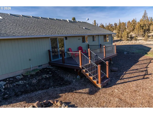 a view of a house with wooden deck and furniture