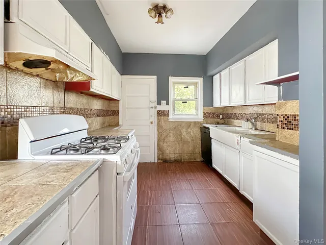 a kitchen with a stove a sink a refrigerator and window
