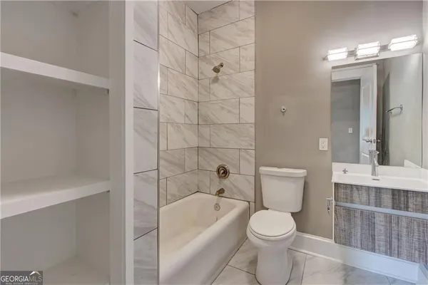 a white toilet sitting next to a bathroom sink and a bathtub