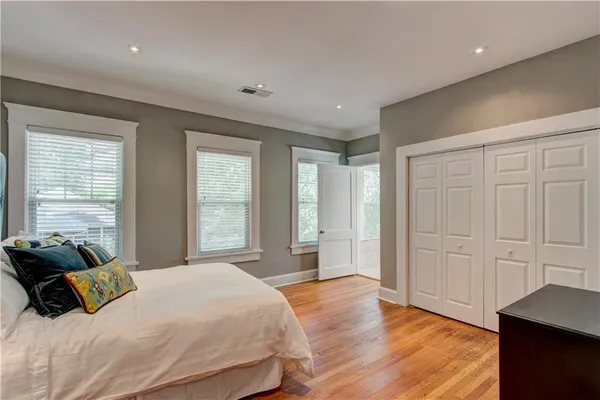a spacious bedroom with a large bed and wooden floor