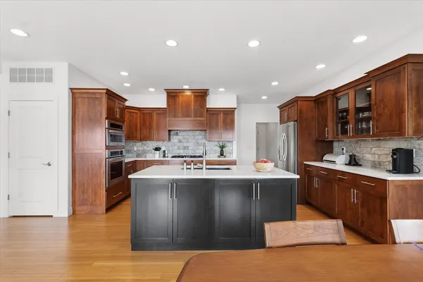 a kitchen with stainless steel appliances granite countertop a sink stove and refrigerator