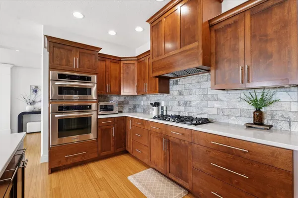 a kitchen with stainless steel appliances granite countertop a stove a sink and a microwave
