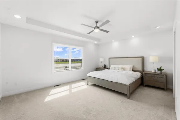a bed room with a bed and a ceiling fan