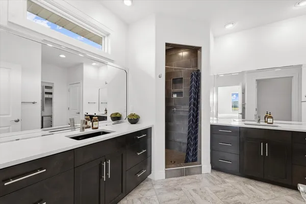 a en suite bathroom with a double vanity sink and a mirror
