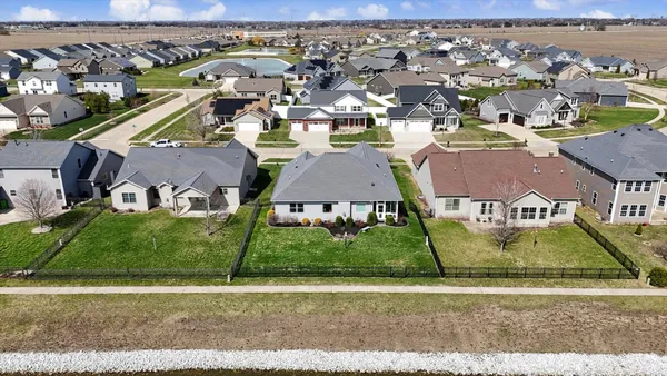 an aerial view of ocean and residential houses with outdoor space