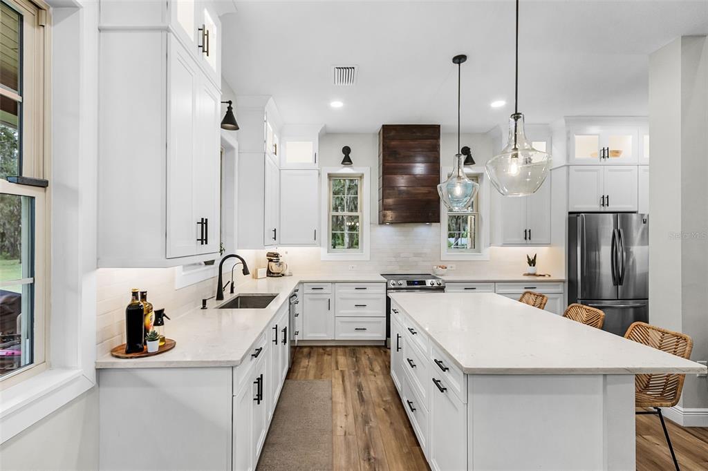 11720 Darsey Road Parrish, FL 34219 - Photo 16 of 60 a large white kitchen with a sink a counter and stainless steel appliances