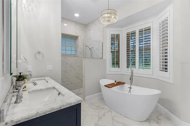 a bathroom with a tub sink and mirror