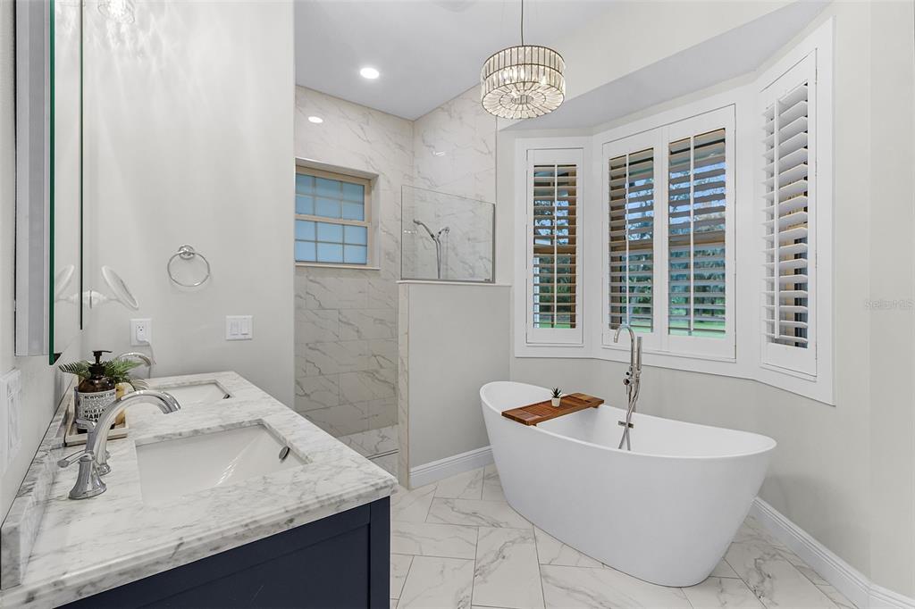 11720 Darsey Road Parrish, FL 34219 - Photo 25 of 60 a bathroom with a tub a sink and a large mirror