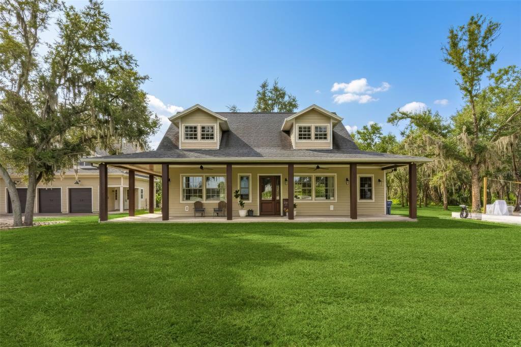 11720 Darsey Road Parrish, FL 34219 - Photo 3 of 60 a view of a white house with a big yard and large trees