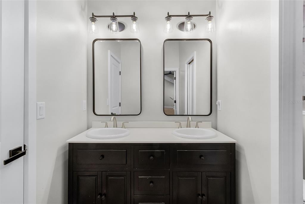 11720 Darsey Road Parrish, FL 34219 - Photo 44 of 60 a bathroom with double vanity sinks and a mirror
