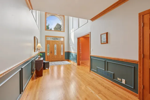 a kitchen with stainless steel appliances granite countertop a kitchen island a stove a sink a dining table and chairs with wooden floor