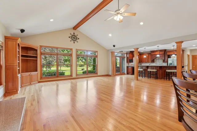a view of an empty room with window and wooden floor