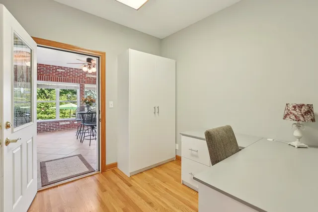 an empty room with windows and chandelier fan