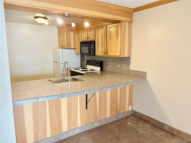 a view of a hallway with wooden floor and a sink