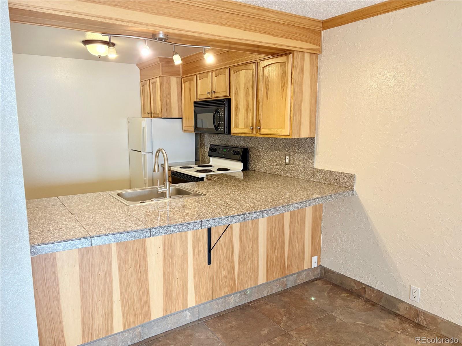 805 29th Street, Unit 253 Boulder, CO 80303 - Photo 4 of 32 a bathroom with a granite countertop sink and a mirror