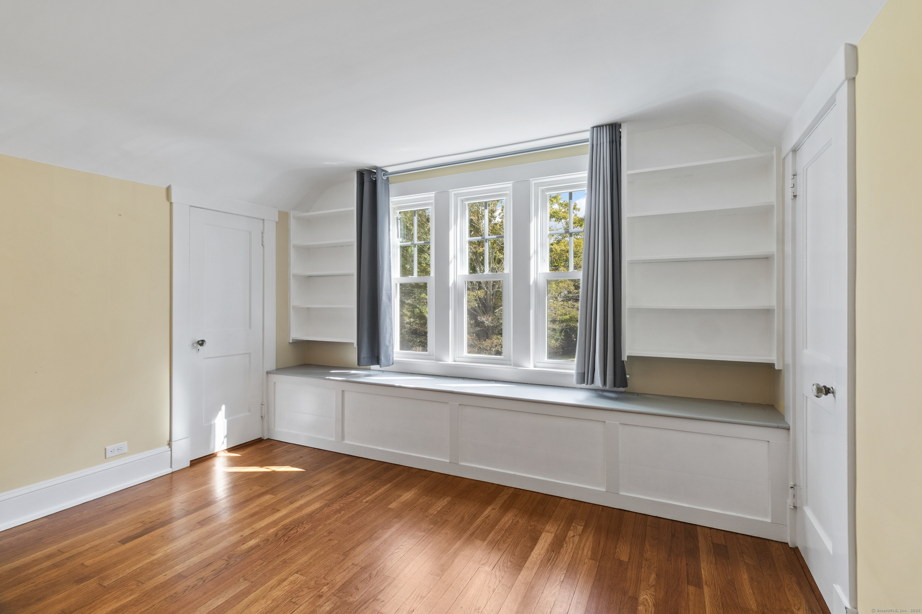 587 Taugwonk Road Stonington, CT 06378 - Photo 25 of 38 a view of an empty room with wooden floor and a window