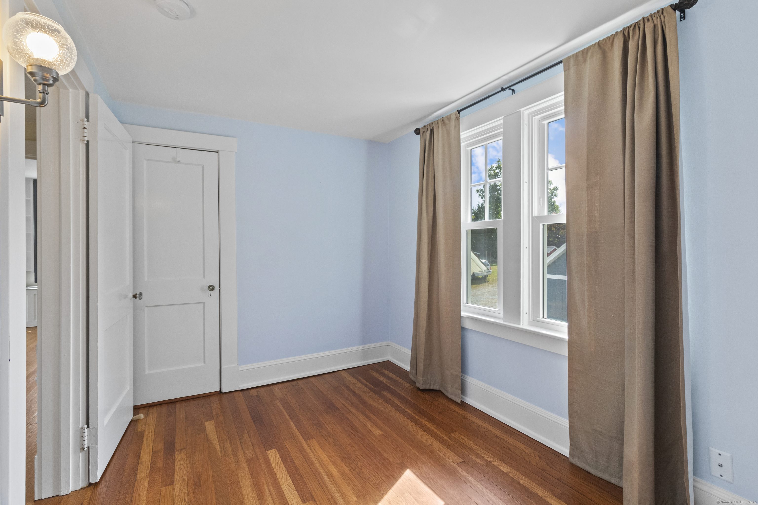 587 Taugwonk Road Stonington, CT 06378 - Photo 28 of 38 a view of an empty room with wooden floor and a window