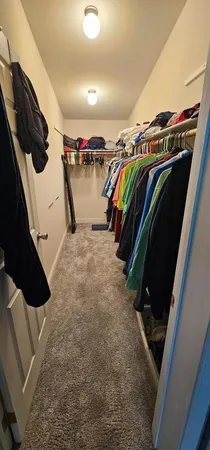 a view of walk in closet with clothes and shoes