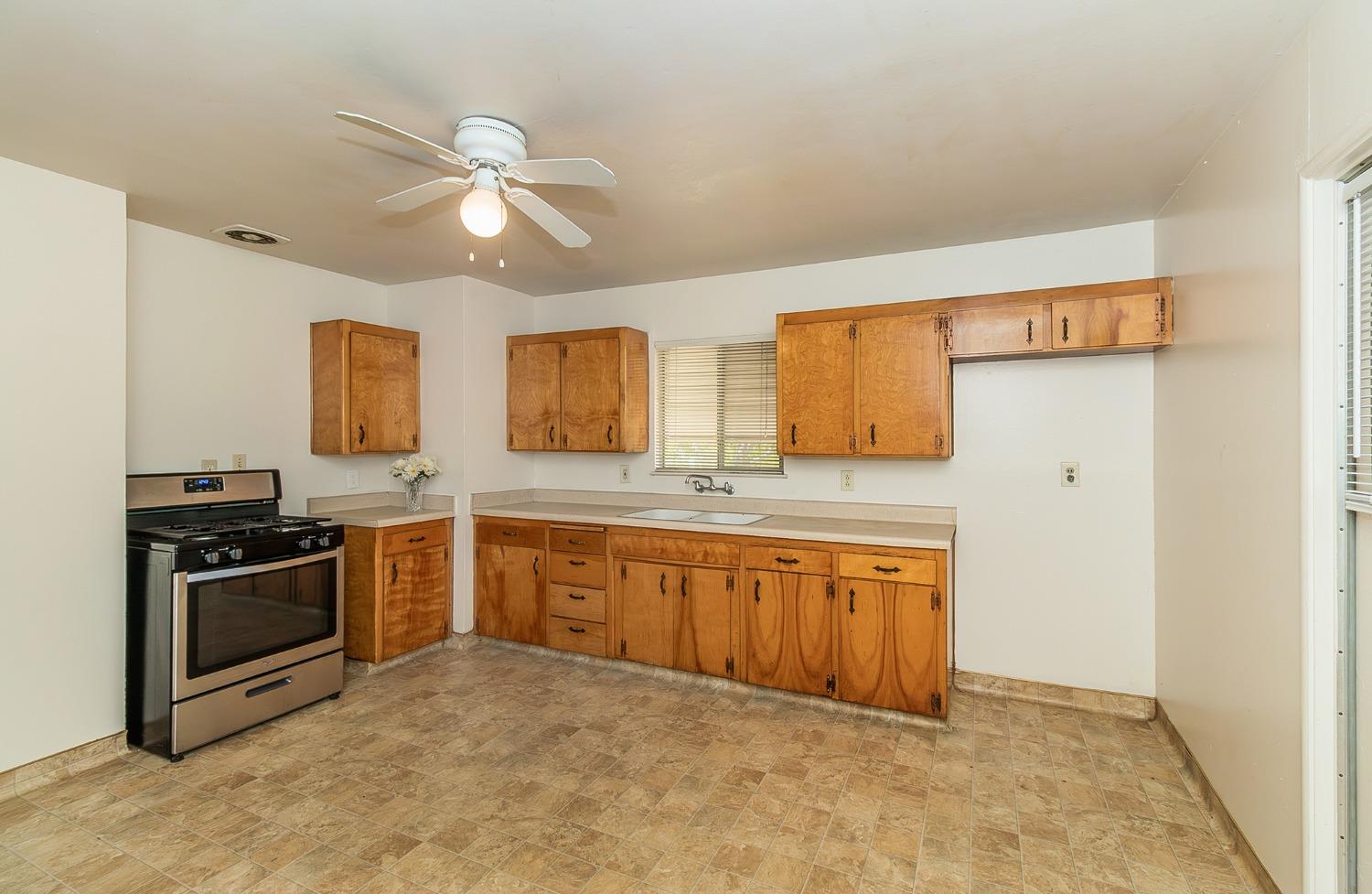 902 Music Avenue Clovis, CA 93612 - Photo 5 of 21 a large kitchen with granite countertop a stove a sink and a refrigerator