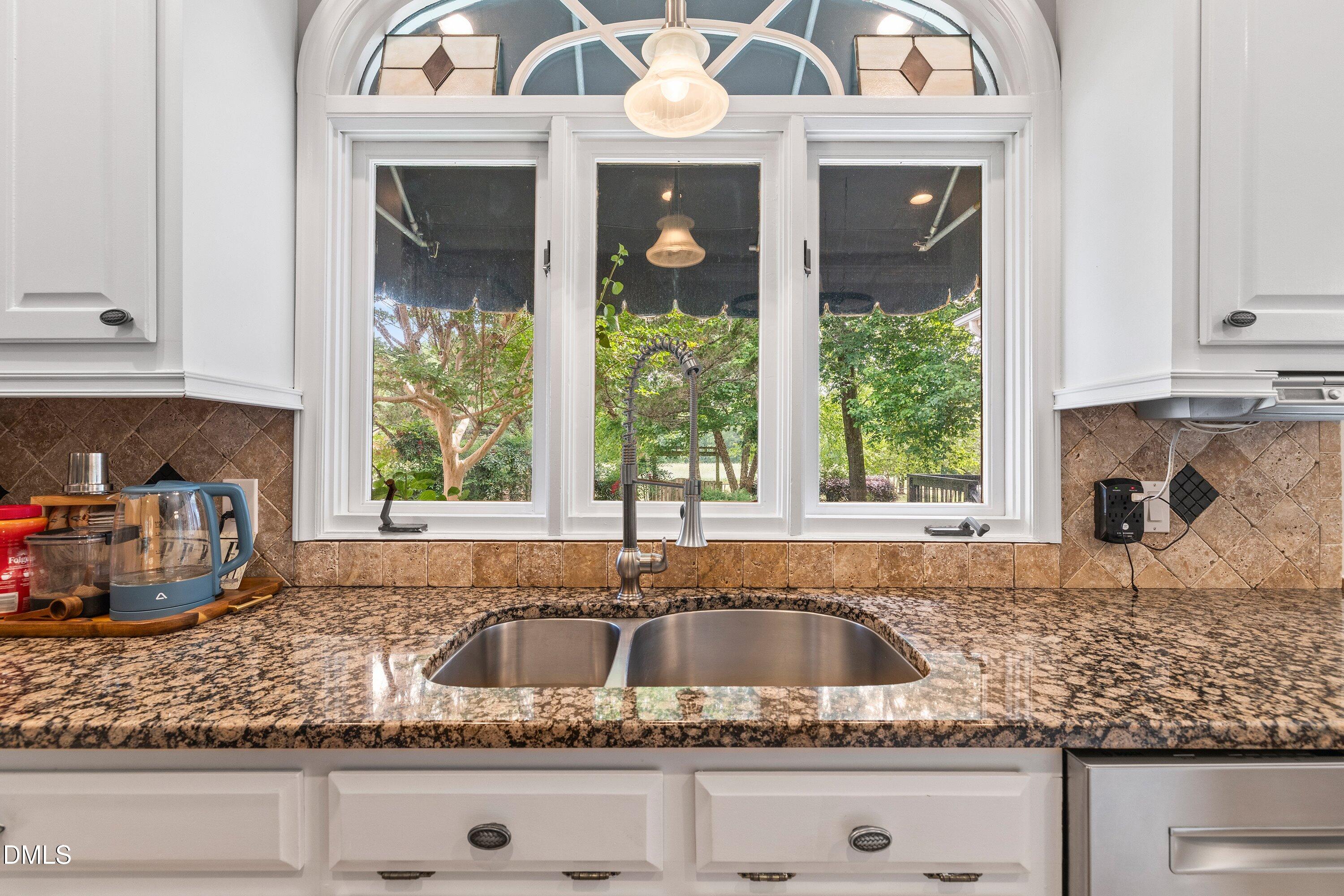 6612 Fowler Road Zebulon, NC 27597 - Photo 10 of 42 a kitchen with granite countertop a sink window and cabinets