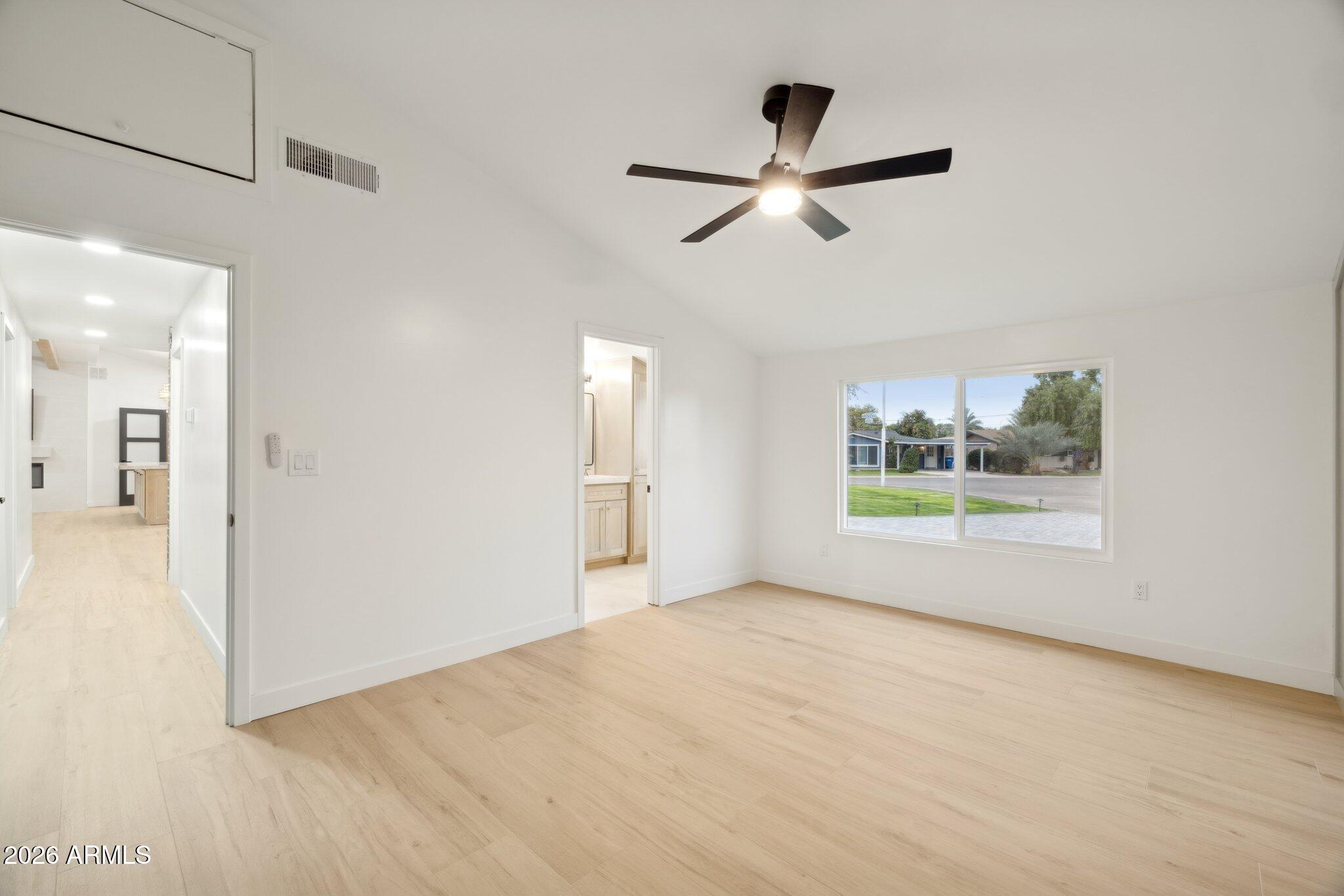 1216 West Rovey Avenue Phoenix, AZ 85013 - Photo 15 of 45 a view of empty room with wooden floor and windows