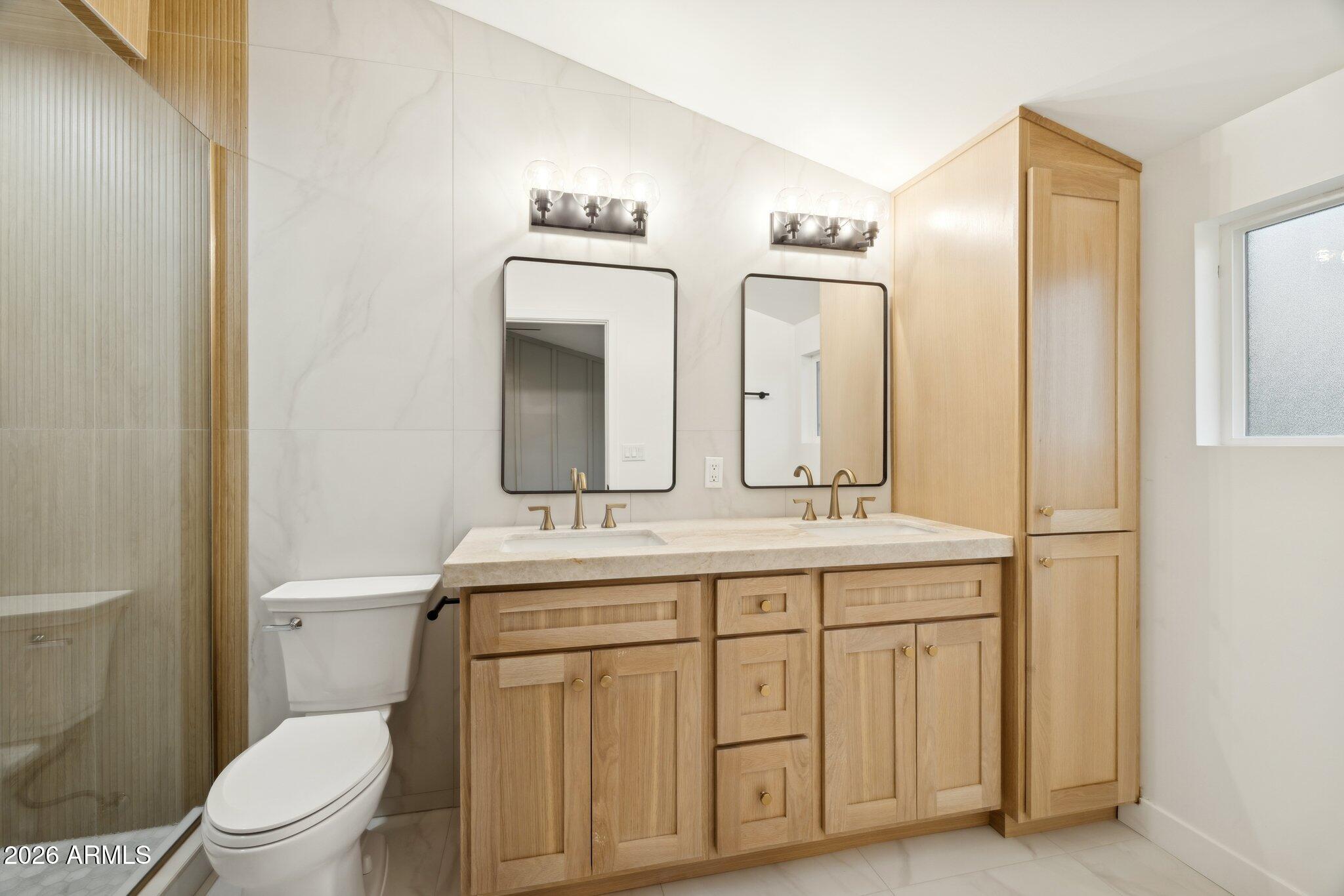 1216 West Rovey Avenue Phoenix, AZ 85013 - Photo 19 of 45 a bathroom with a toilet a sink a vanity and mirror