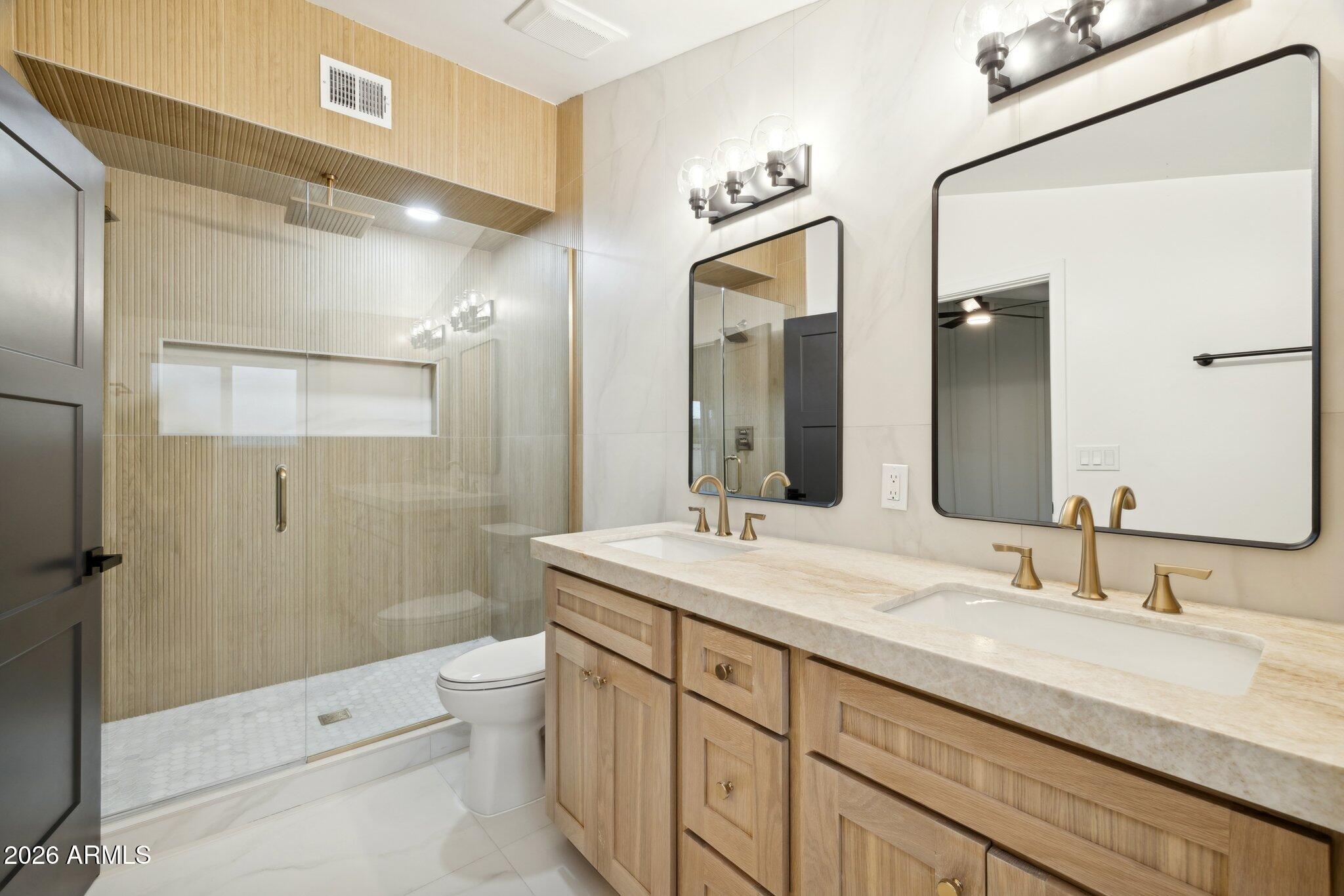 1216 West Rovey Avenue Phoenix, AZ 85013 - Photo 20 of 45 a bathroom with a granite countertop sink a toilet a mirror and shower