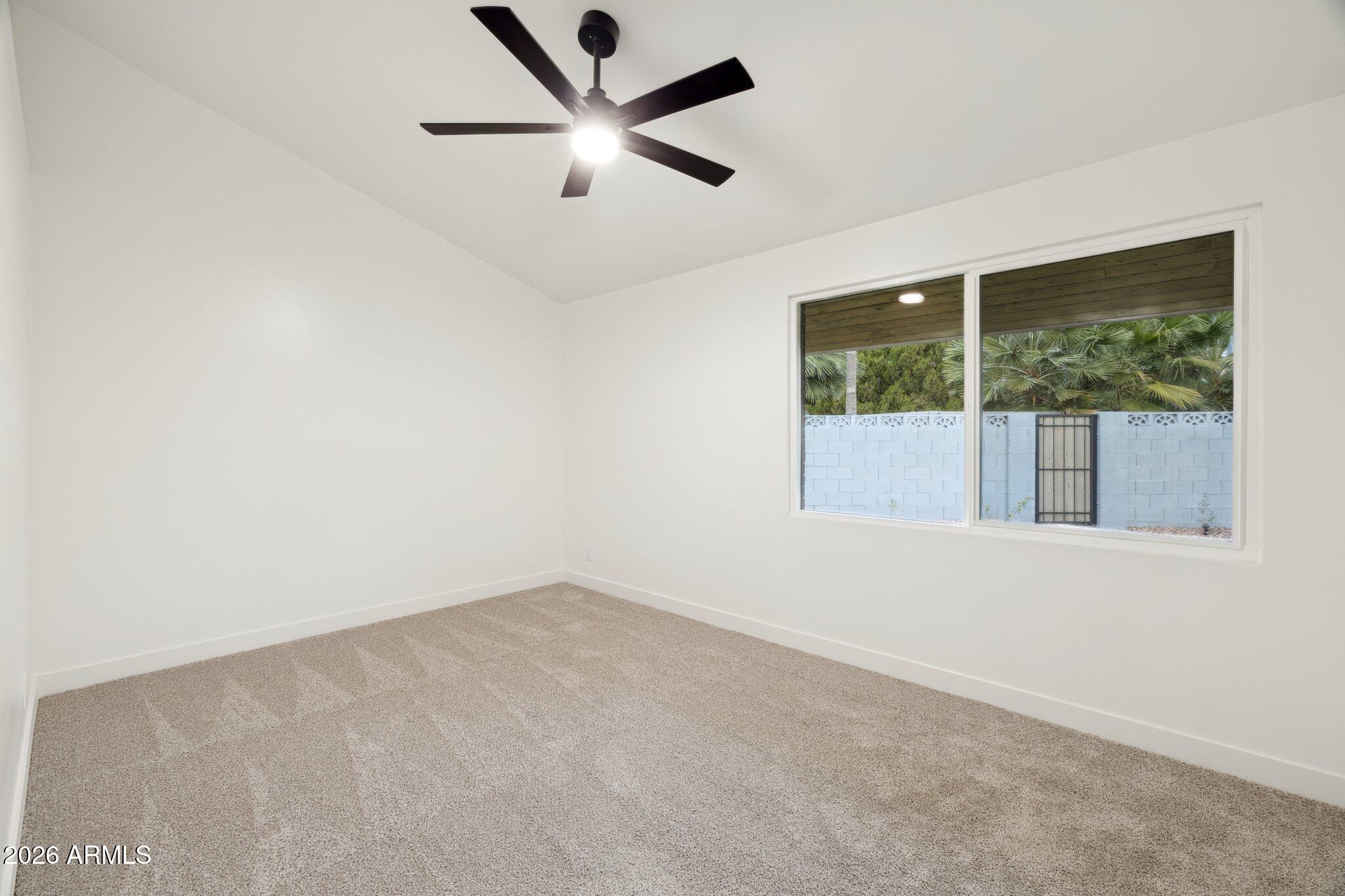 1216 West Rovey Avenue Phoenix, AZ 85013 - Photo 27 of 45 an empty room with a window and a ceiling fan