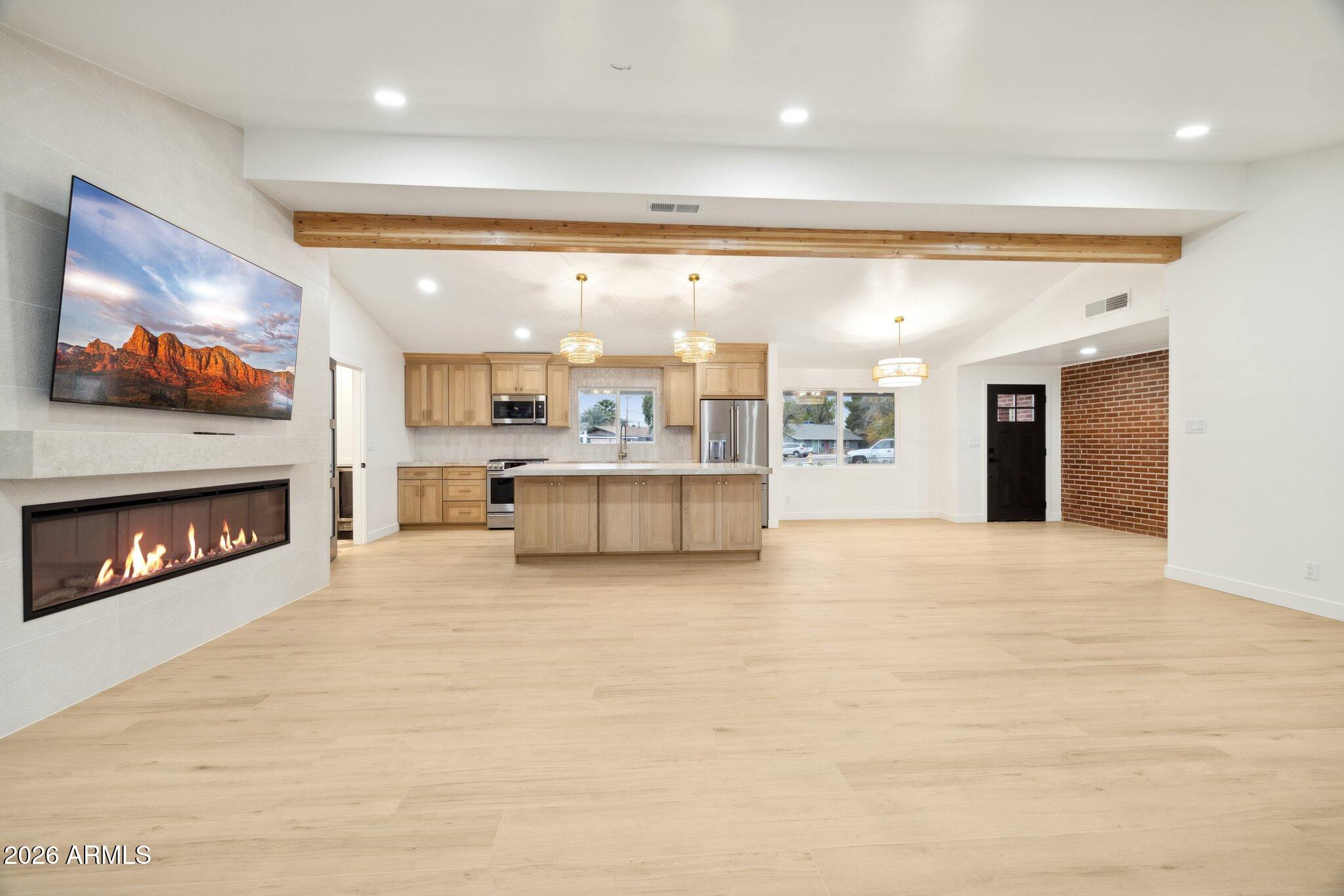 1216 West Rovey Avenue Phoenix, AZ 85013 - Photo 6 of 45 a large hall with a fireplace and a flat screen tv
